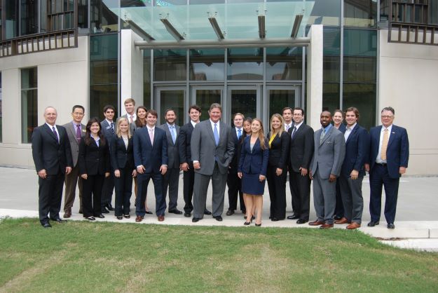 Jim Flores stands in front of BEC Rotunda with group of students.