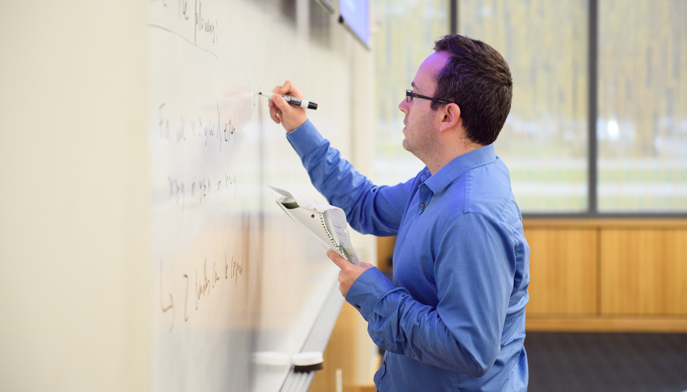 student writing on whiteboard