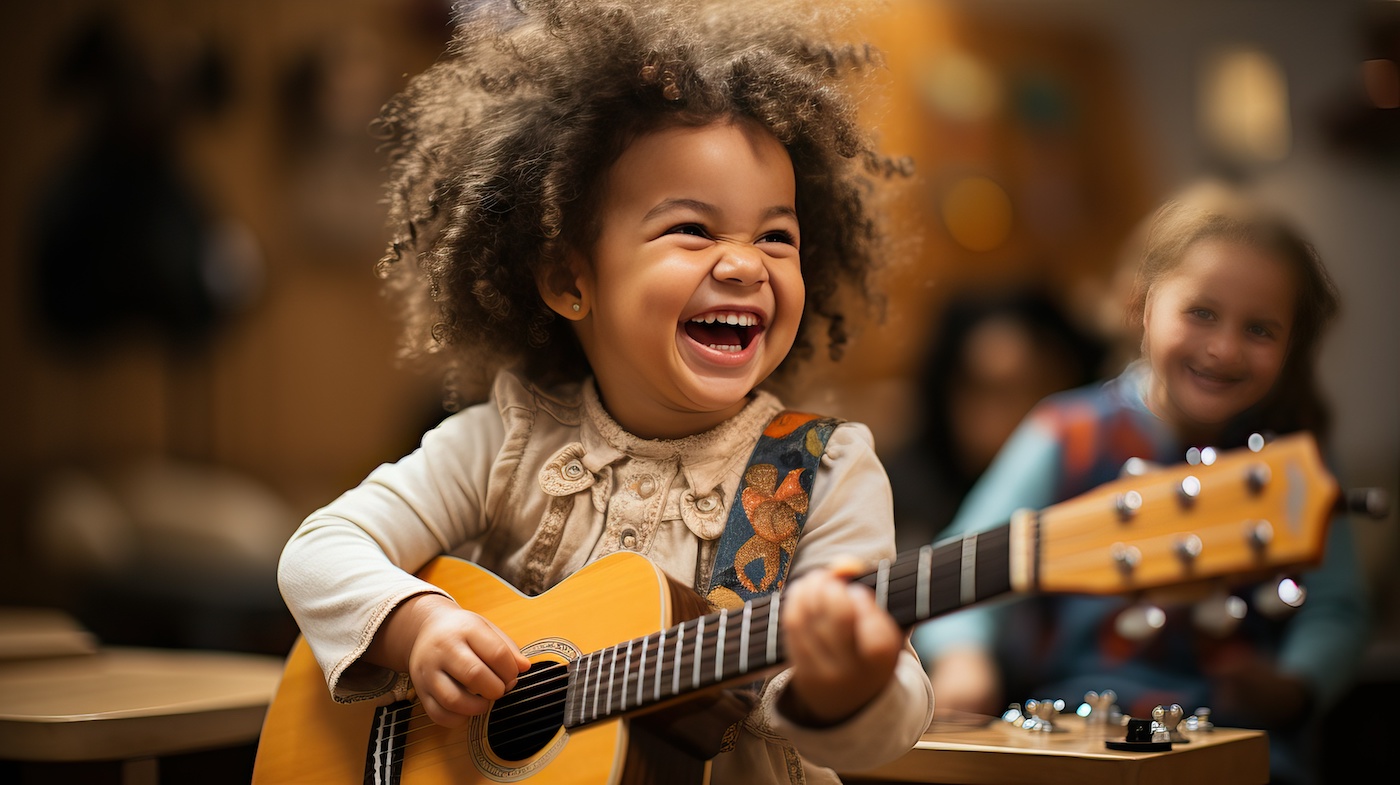 child playing guitar Child smiling while playing the guitaer