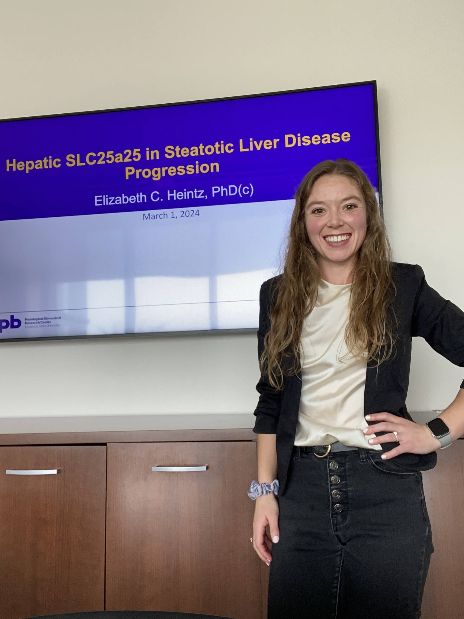 Elizabeth Heintz standing in front of a tv screen